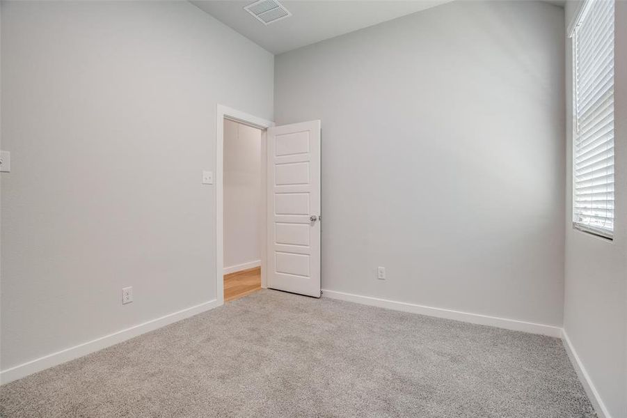 Spare room with light carpet and baseboards