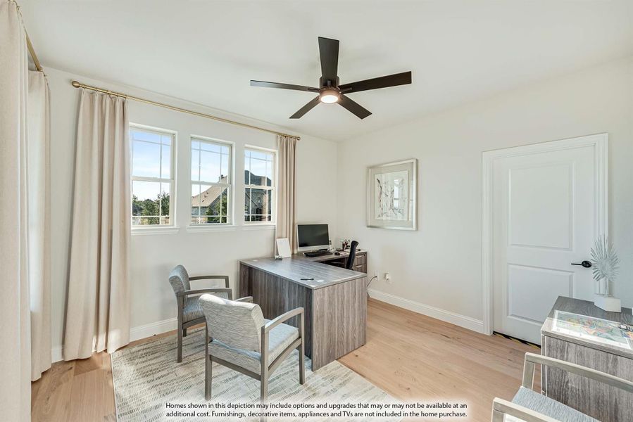 Home office with wood desk, ceiling fan, hardwood floors, and two windows with natural light