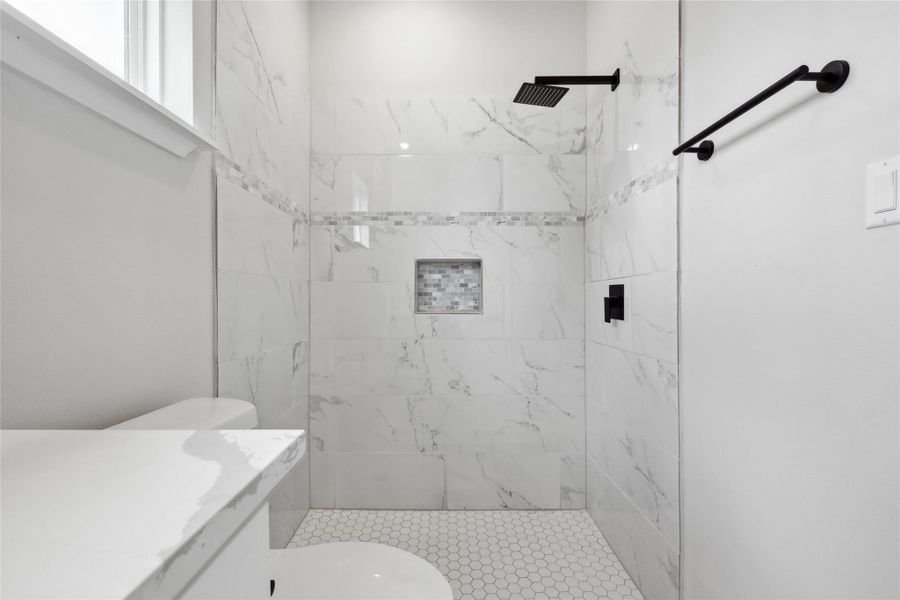 Full bathroom featuring toilet, a tile shower, and vanity Full bathroom featuring toilet, a tile shower, and vanity