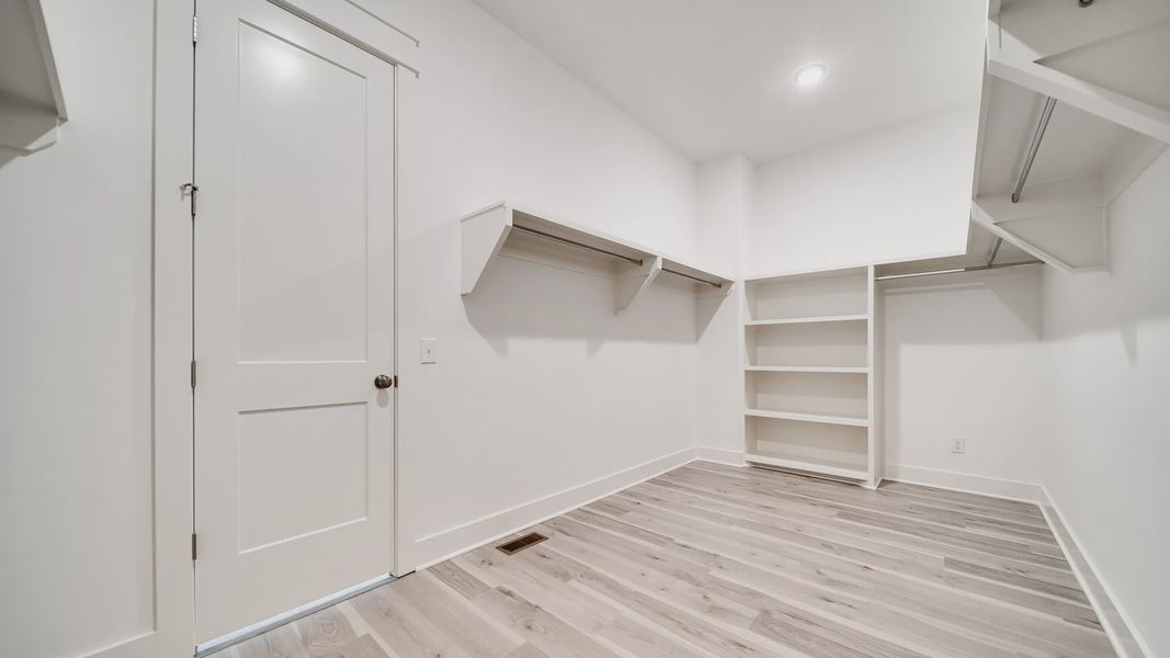 Large walk-in closet showing built-in shelving