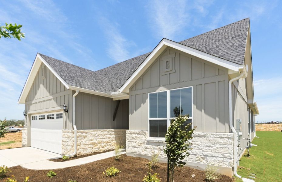 Front exterior of a new home in Del Webb Austin at Lost Pines, Bastrop, TX, highlighting curb appeal (Image 21). Front exterior of a new home in Del Webb Austin at Lost Pines, Bastrop, TX, highlighting curb appeal (Image 21).