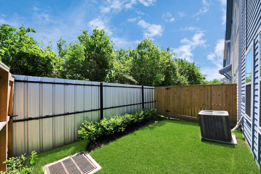 The home's backyard showcases a beautifully landscaped, fenced area, where lush greenery and neatly trimmed grass create a serene outdoor retreat. The home's backyard showcases a beautifully landscaped, fenced area, where lush greenery and neatly trimmed grass create a serene outdoor retreat.