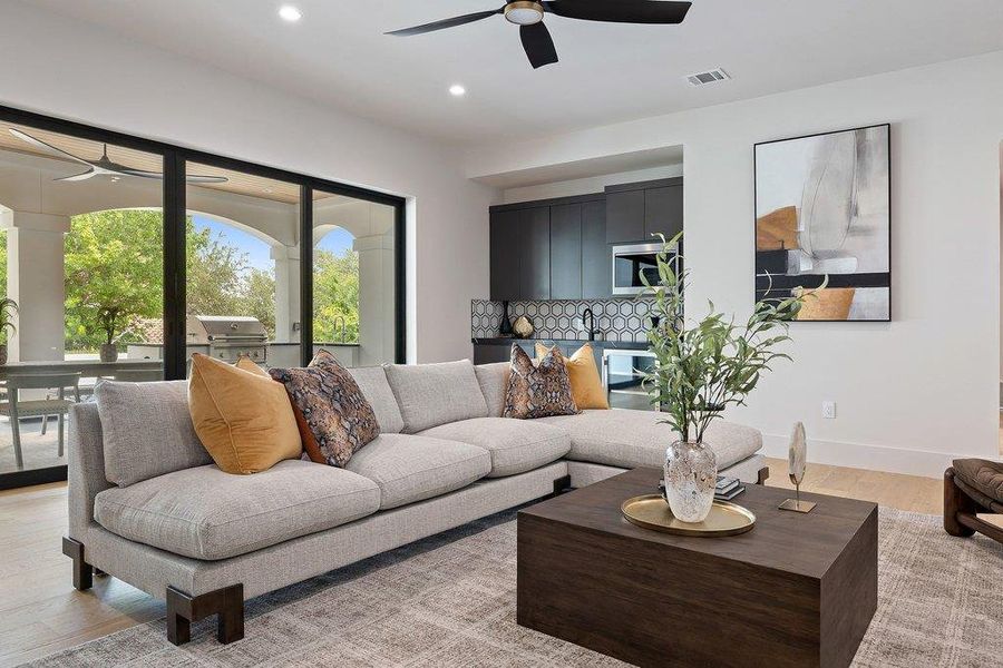 Living area featuring light wood-finish flooring and a contemporary ceiling fan