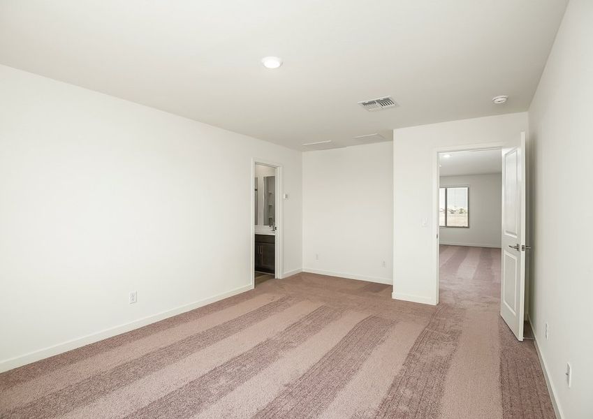 Primary bedroom with ensuite doorway and vinyl flooring in Wellton floor plan