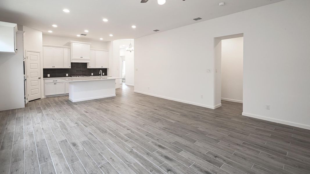 Kitchen with tasteful backsplash, white cabinets, open floor plan, recessed lighting, and a center island with sink Kitchen with tasteful backsplash, white cabinets, open floor plan, recessed lighting, and a center island with sink