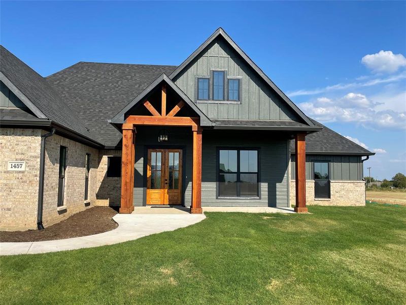 Rear view of house featuring a yard and french doors