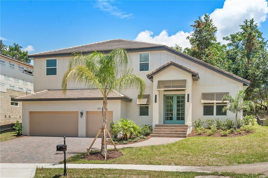 Front exterior view of 531 Sanctuary Golf Pl., showcasing its two-story design, tiled roof, and inviting entrance with steps leading to a beautiful double door.