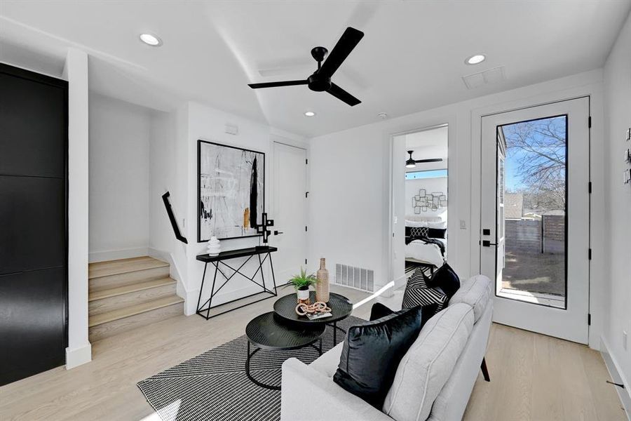 Living room featuring ceiling fan, light wood-type flooring, recessed lighting, baseboards, and stairs