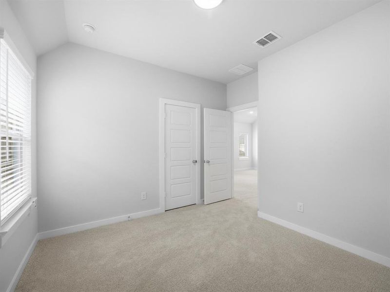 Unfurnished bedroom featuring light colored carpet and baseboards