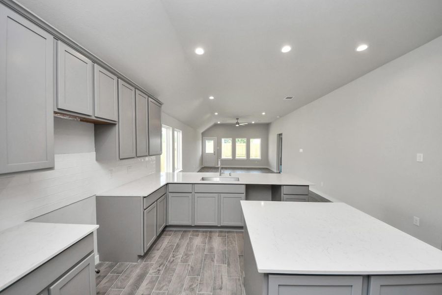 The kitchen is a culinary haven, featuring granite countertops, a tile backsplash, stainless steel appliances, and 42” upper cabinets. Sample photo of completed home with similar floor plan. Actual colors and selections may vary. The kitchen is a culinary haven, featuring granite countertops, a tile backsplash, stainless steel appliances, and 42” upper cabinets. Sample photo of completed home with similar floor plan. Actual colors and selections may vary.