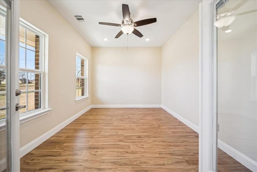 Empty room with wood-type flooring and ceiling fan