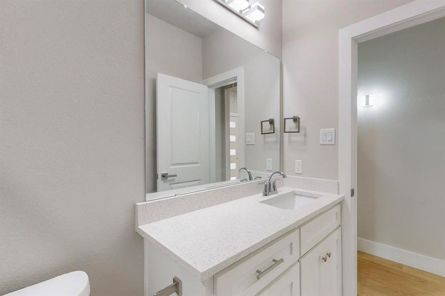 Bathroom with vanity, wood-type flooring, and toilet