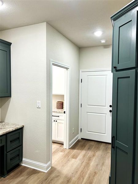 Corridor featuring light wood-style floors and baseboards Corridor featuring light wood-style floors and baseboards