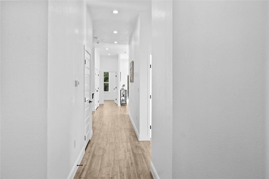 Hallway with light wood-style flooring and recessed lighting Hallway with light wood-style flooring and recessed lighting