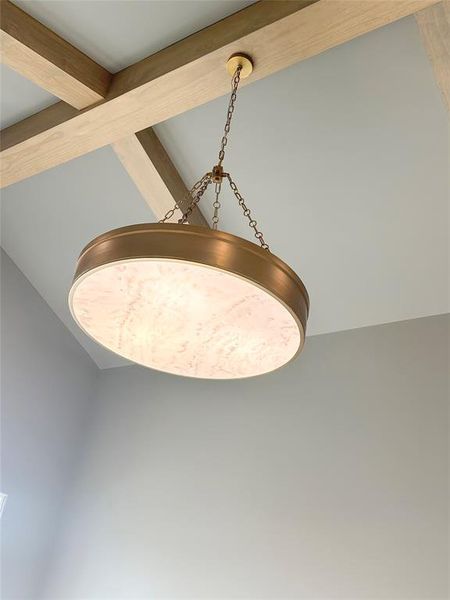 Vaulted ceiling with beamed wood and Visual Comfort chandelier.