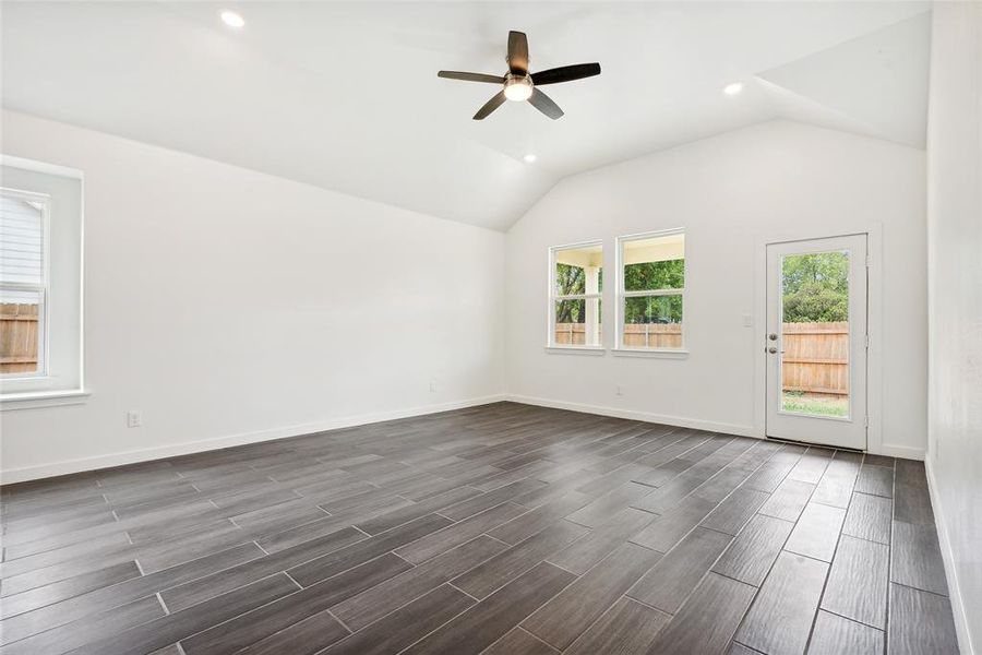 Spare room with lofted ceiling, dark wood-type flooring, and ceiling fan