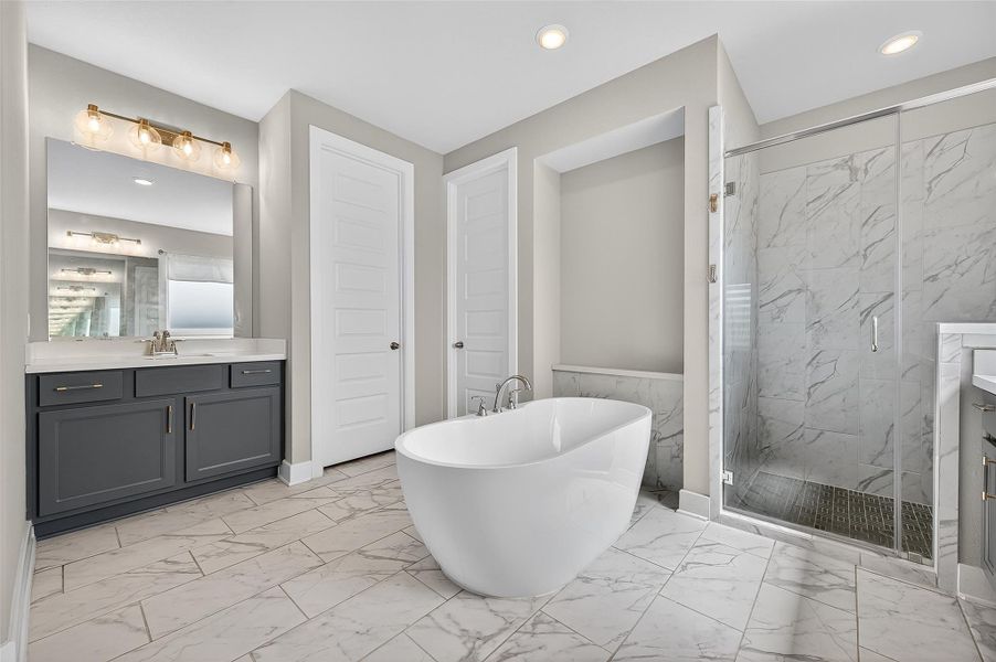 Unwind in luxury with this stunning en-suite featuring a sculptural tub, frameless glass shower, and rich cabinetry. The thoughtful layout blends relaxation and refined design.