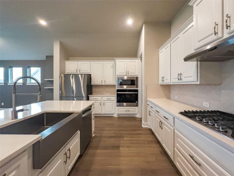 Kitchen with stainless steel appliances, white cabinets, backsplash, and recessed lighting Kitchen with stainless steel appliances, white cabinets, backsplash, and recessed lighting