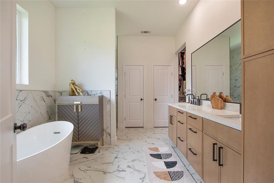 Full bathroom featuring double vanity, a soaking tub, light marble finish flooring, and recessed lighting Full bathroom featuring double vanity, a soaking tub, light marble finish flooring, and recessed lighting