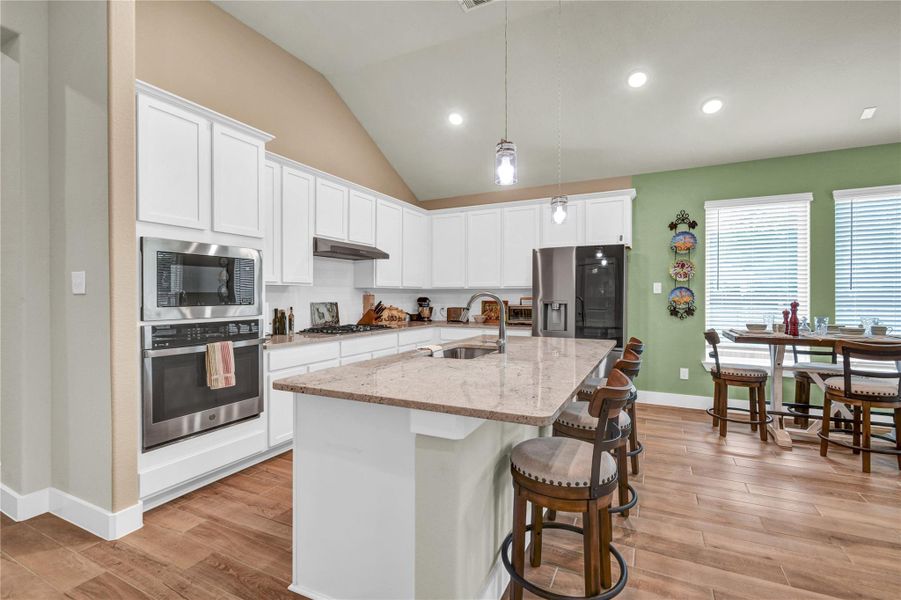 Breakfast bar with granite countertops and an undermount kitchen sink. Kitchen also features a built in gas oven and microwave Breakfast bar with granite countertops and an undermount kitchen sink. Kitchen also features a built in gas oven and microwave
