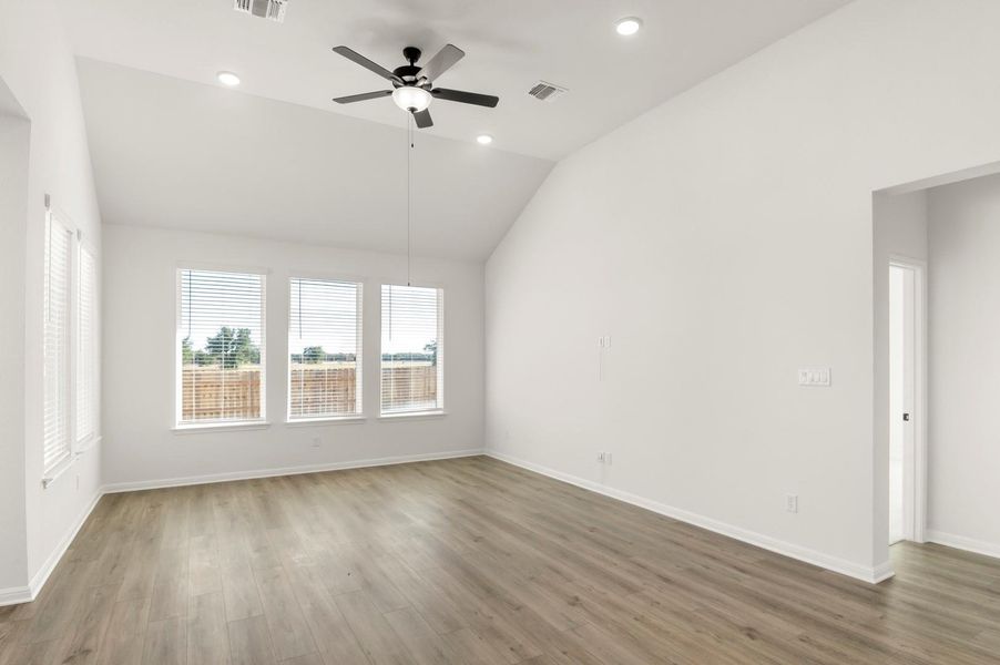 Unfurnished room with wood finished floors, a ceiling fan, vaulted ceiling, and recessed lighting
