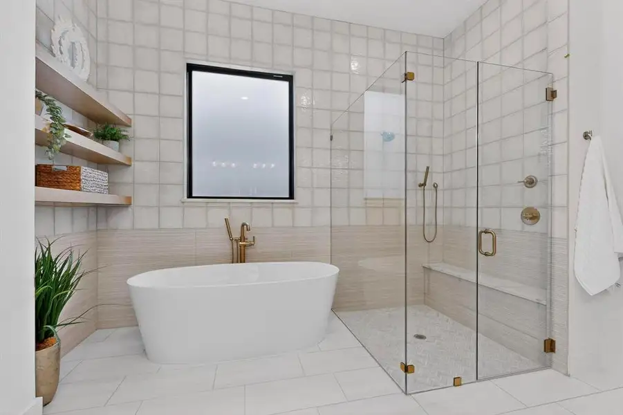 Slipper tub and frameless glass shower with full tile surround.