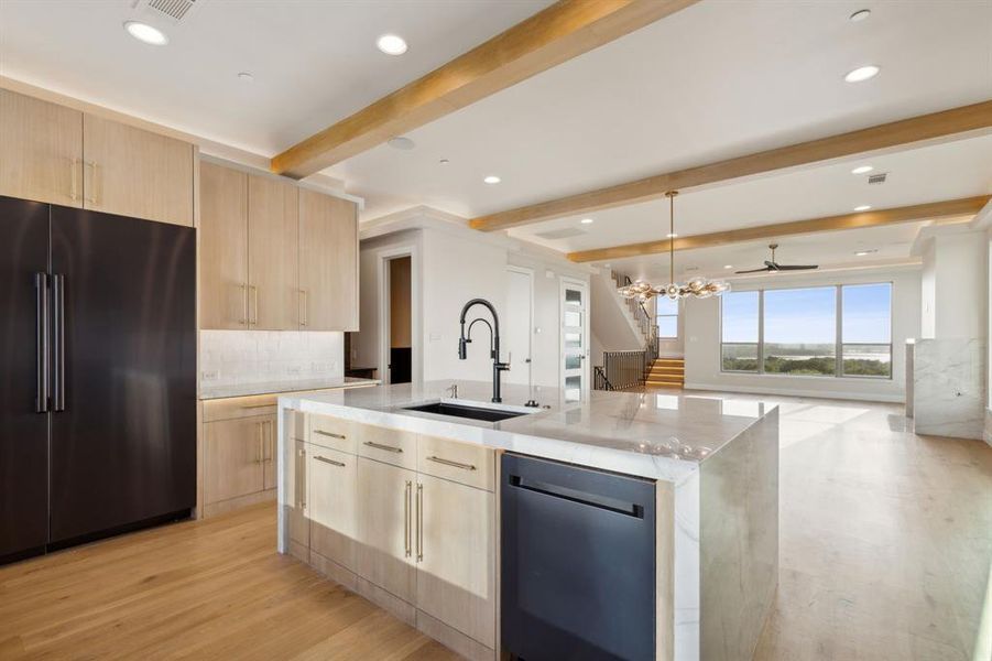 Kitchen with high end refrigerator, light brown cabinetry, modern cabinets, a sink, and dishwashing machine