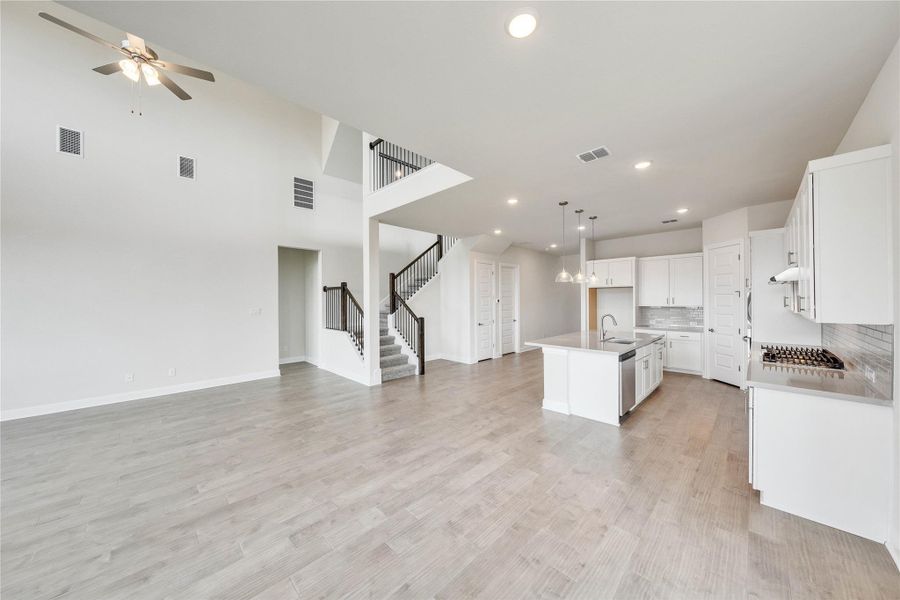 Kitchen with open floor plan, a ceiling fan, a center island with sink, white cabinetry, and recessed lighting Kitchen with open floor plan, a ceiling fan, a center island with sink, white cabinetry, and recessed lighting