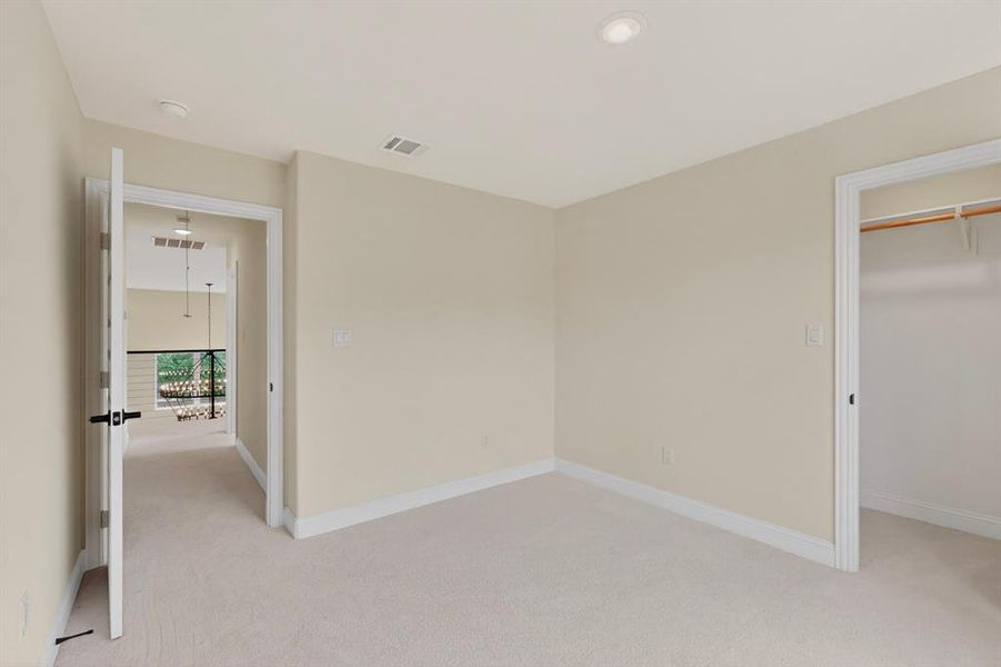Carpeted room with recessed lighting and a walk-in closet featuring built-in shelving