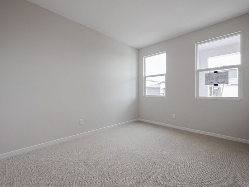 A room with a carpet and a window.