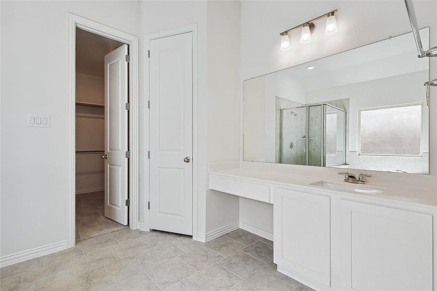 Bathroom with vanity, an enclosed shower, and tile patterned flooring