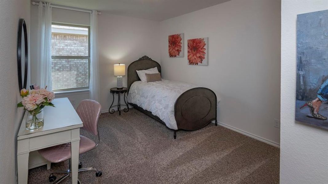 Carpeted bedroom with a desk and baseboards