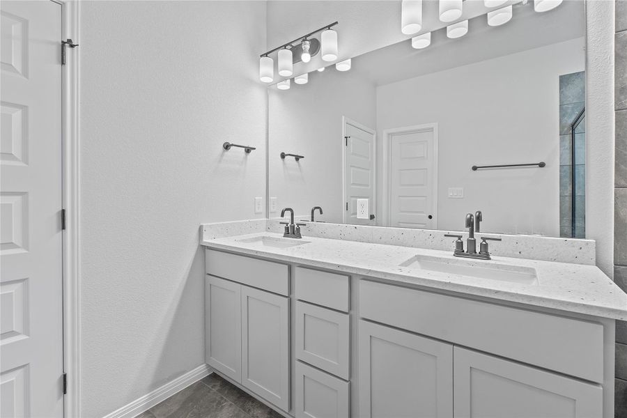 Full bath with double vanity and a shower