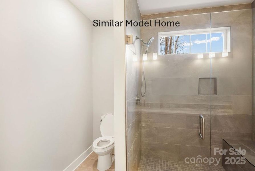 Primary suite low profile walk-in shower with ceramic tile surround and window Primary suite low profile walk-in shower with ceramic tile surround and window