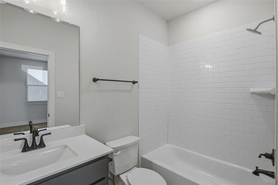 Full bath featuring vanity, shower / washtub combination, and a textured wall