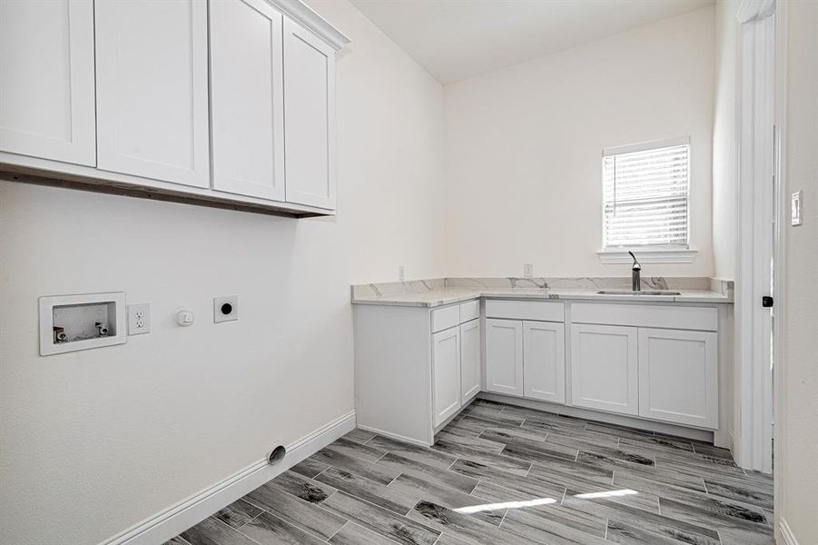 Laundry room with gas dryer hookup, cabinets, sink, hookup for a washing machine, and hookup for an electric dryer