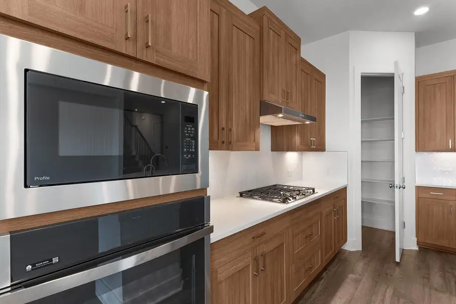 Culinary delights await in this modern kitchen, featuring stainless steel appliances and ample cabinetry.