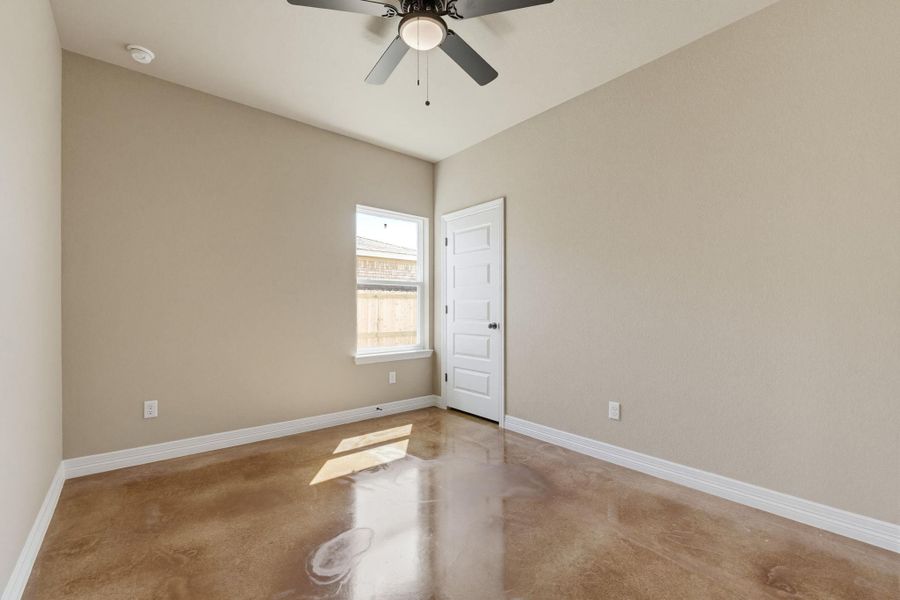 Empty room with concrete floors and ceiling fan