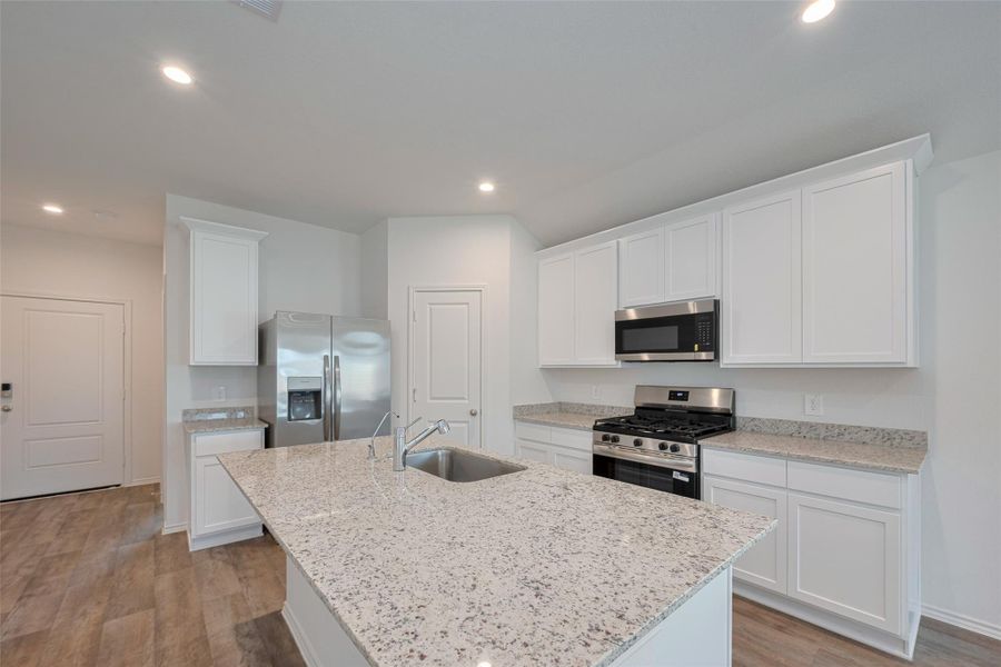 Crisp white cabinetry—both overhead and below—provides abundant storage, while granite countertops offer ample room for cooking, entertaining, or display. Crisp white cabinetry—both overhead and below—provides abundant storage, while granite countertops offer ample room for cooking, entertaining, or display.