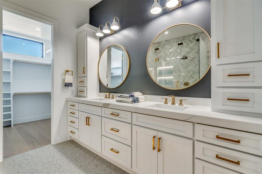 Model Home Bathroom with double vanity, a stall shower, and a walk in closet