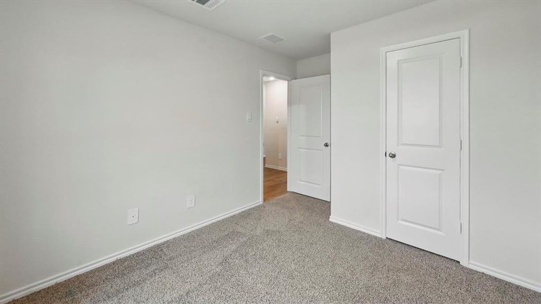 Room featuring light gray walls, gray carpet, and white trim