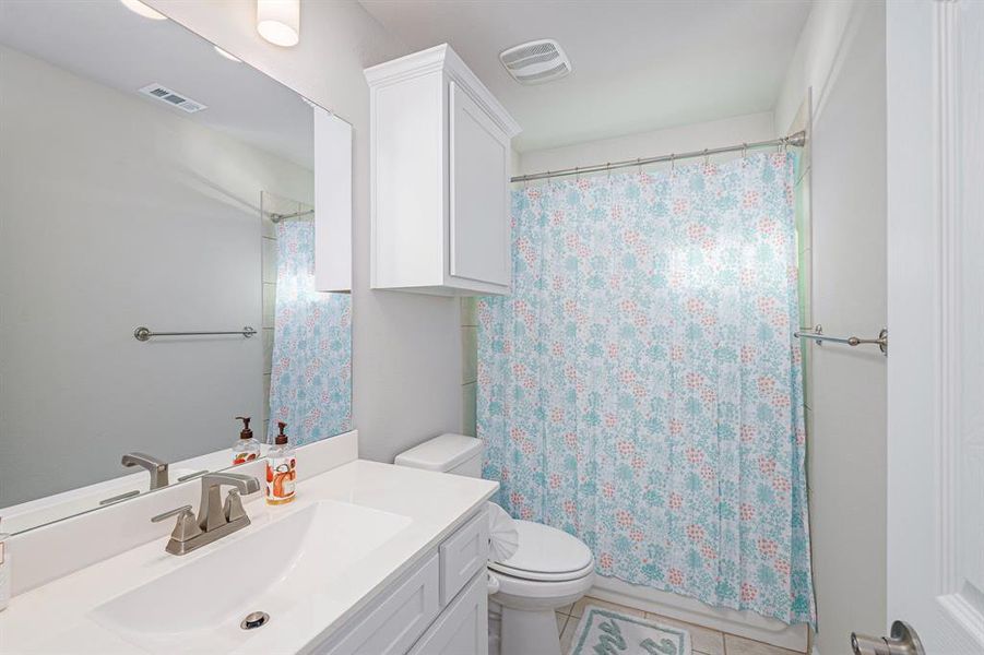 Bathroom featuring tile patterned flooring, vanity, and toilet