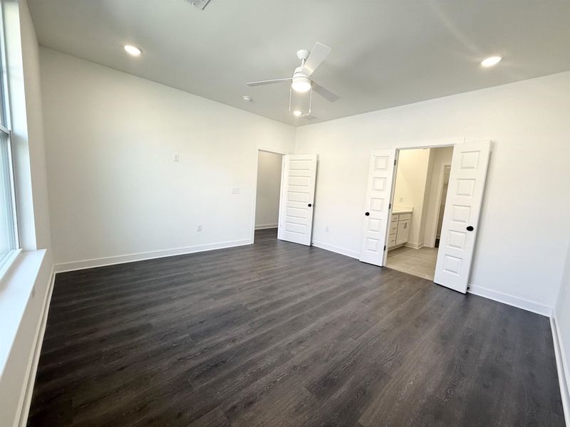 Unfurnished bedroom with a ceiling fan, dark wood-style floors, recessed lighting, and ensuite bathroom