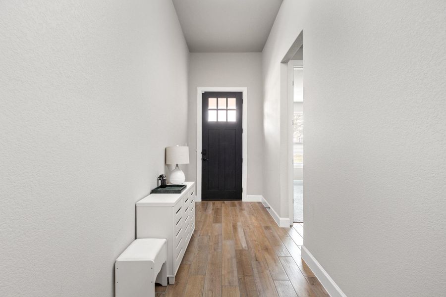 Doorway to outside with a textured wall and hardwood / wood-style flooring