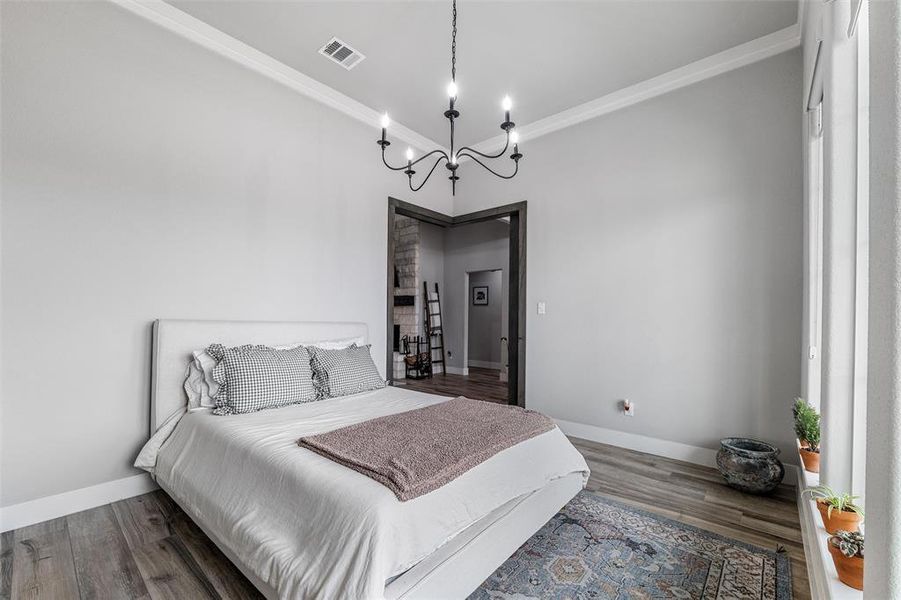 Bedroom with crown molding, dark hardwood / wood-style floors, and an inviting chandelier