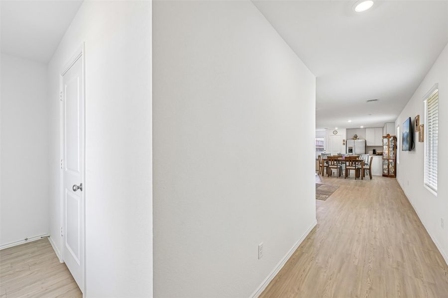 Hallway with light wood-finish flooring and recessed lighting Hallway with light wood-finish flooring and recessed lighting