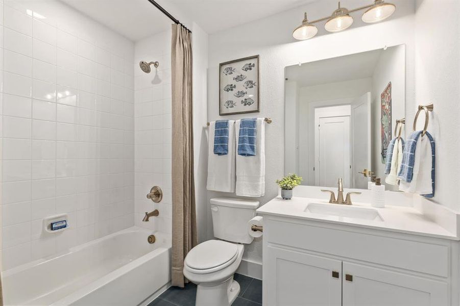 Full bathroom featuring dark tile patterned floors, shower / bath combo with shower curtain, and vanity Full bathroom featuring dark tile patterned floors, shower / bath combo with shower curtain, and vanity