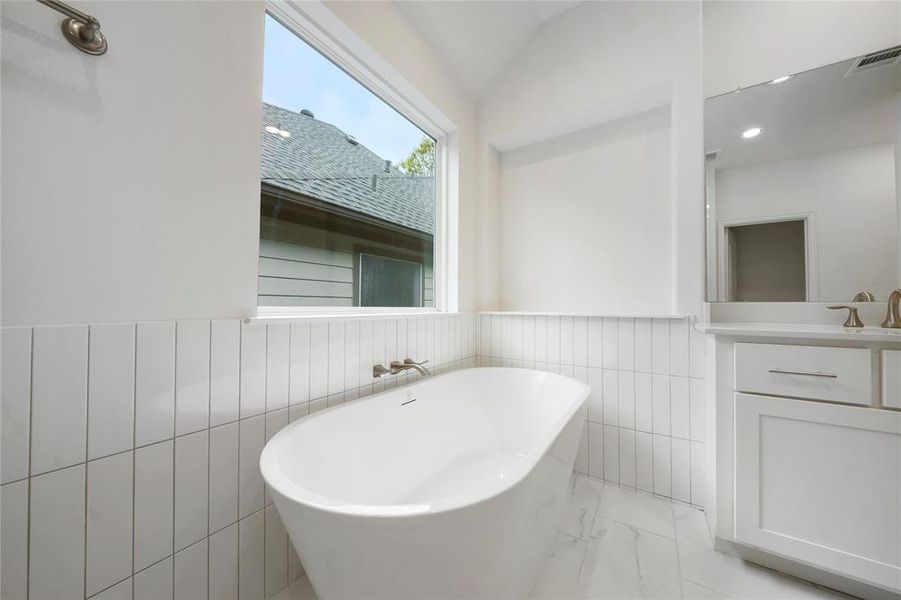 The Primary Bath stand-alone tub is surrounded by Emser Tile. (Sample photos of a completed Chesapeake floor plan. The image may feature alternative selections and/or upgrades.