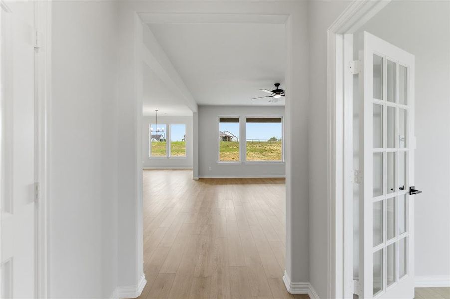 Hallway with light wood-style floors and baseboards
