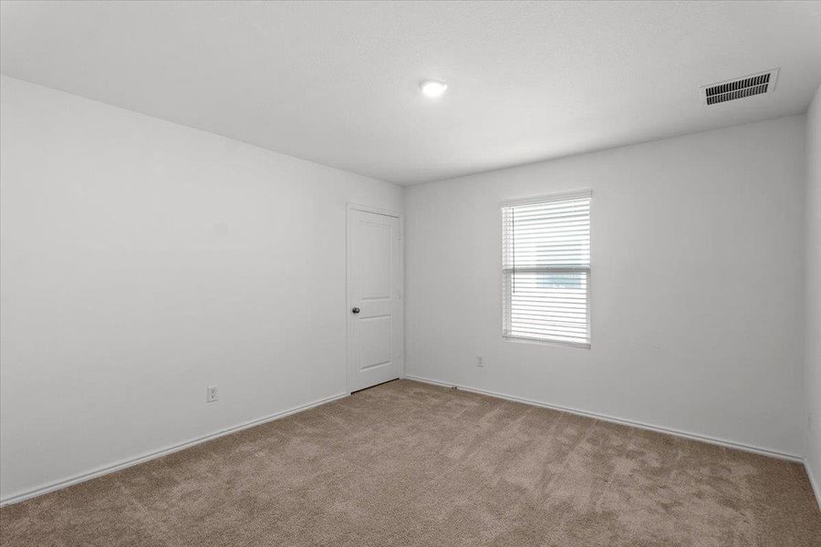 A well-lit bedroom offering a blank canvas for personalization. A well-lit bedroom offering a blank canvas for personalization.